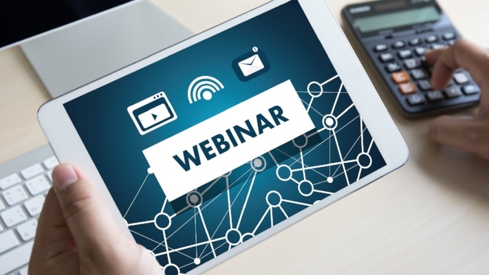 Person holding tablet with webinar on it